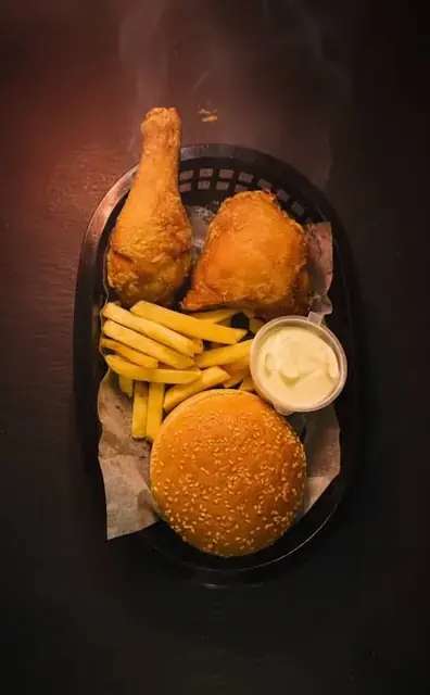 Broast, a bun, fries, and dip in a basket.